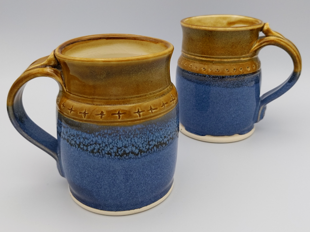 the plus mug in white stoneware with bright blue and golden brown glazes