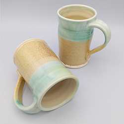 Stoneware mug with a watery blue-green glaze over a sandy tan glaze.